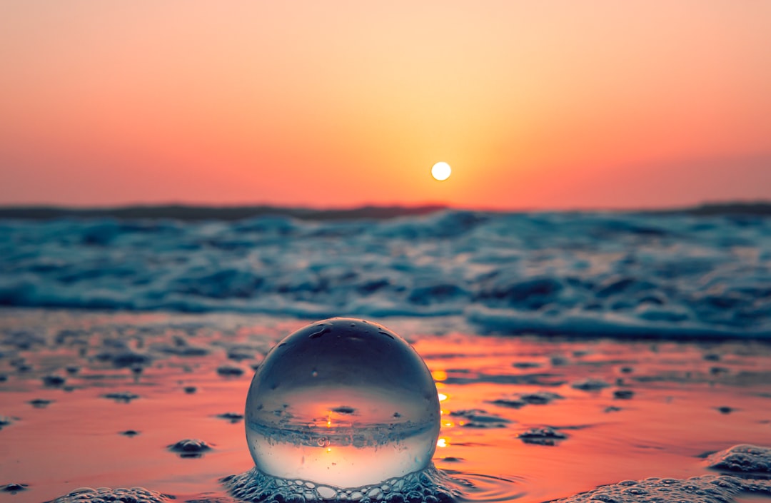 clear glass ball on water during daytime