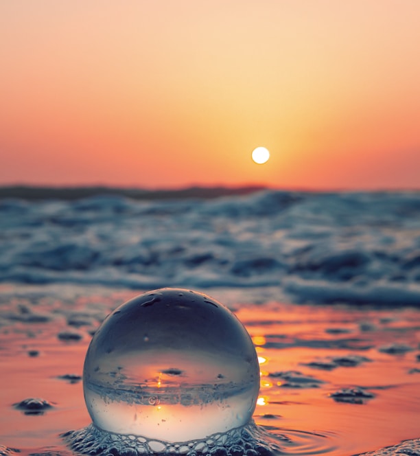 clear glass ball on water during daytime