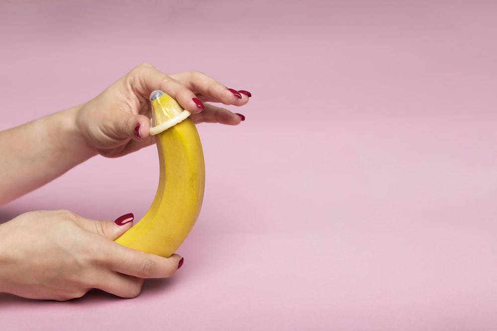 persona sosteniendo una fruta de plátano amarillo