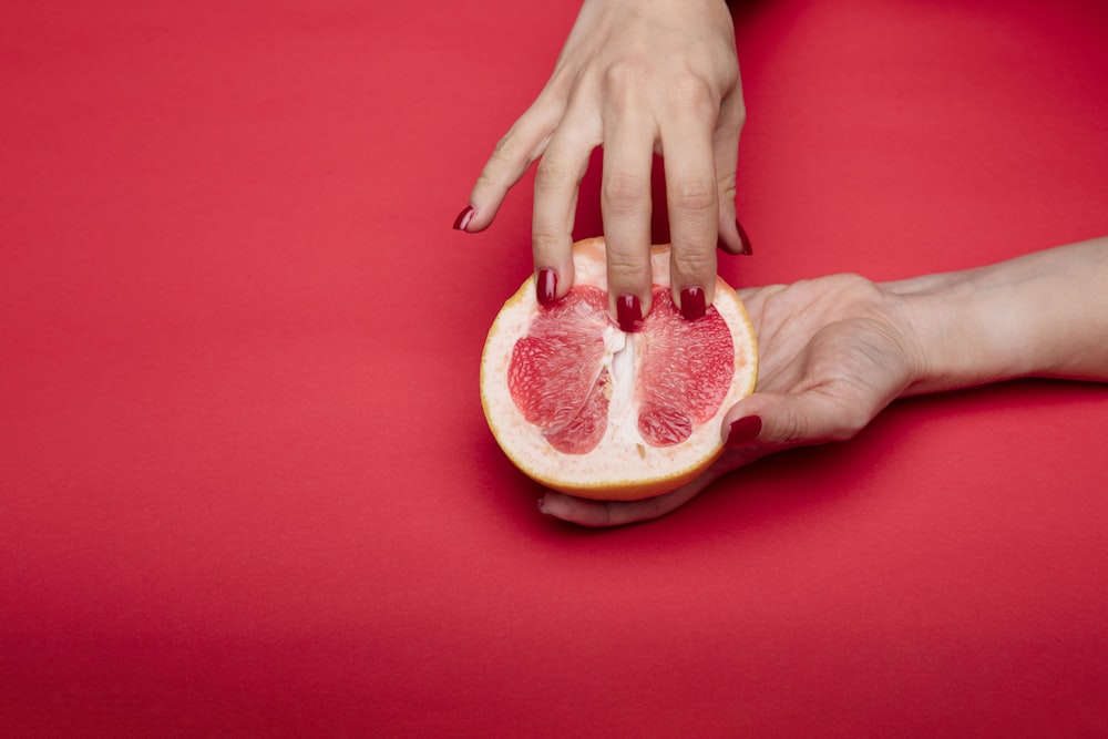 sliced orange fruit on red textile