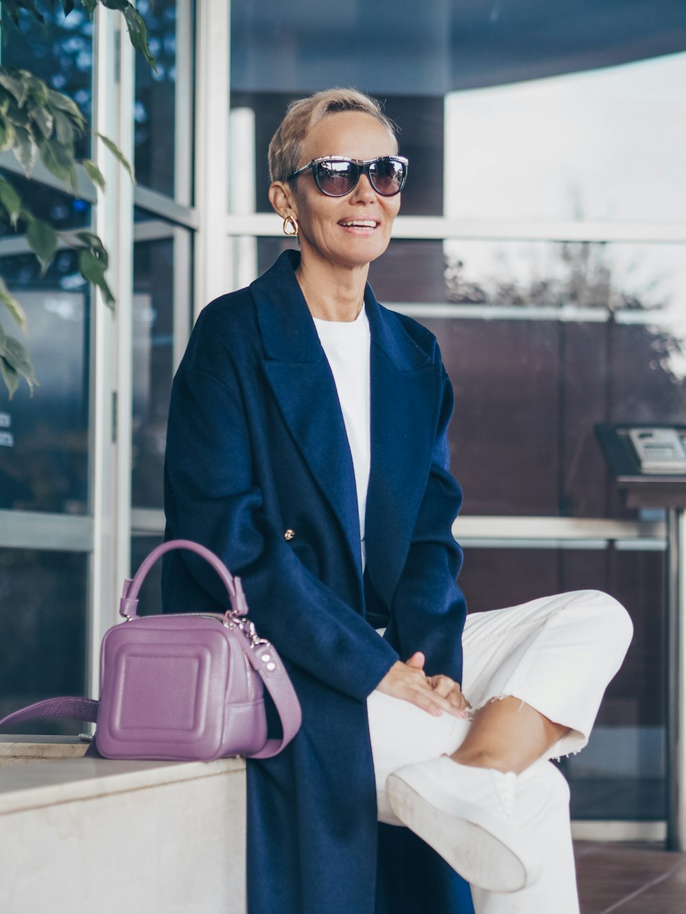 woman in blue blazer and white dress shirt with pink leather handbag