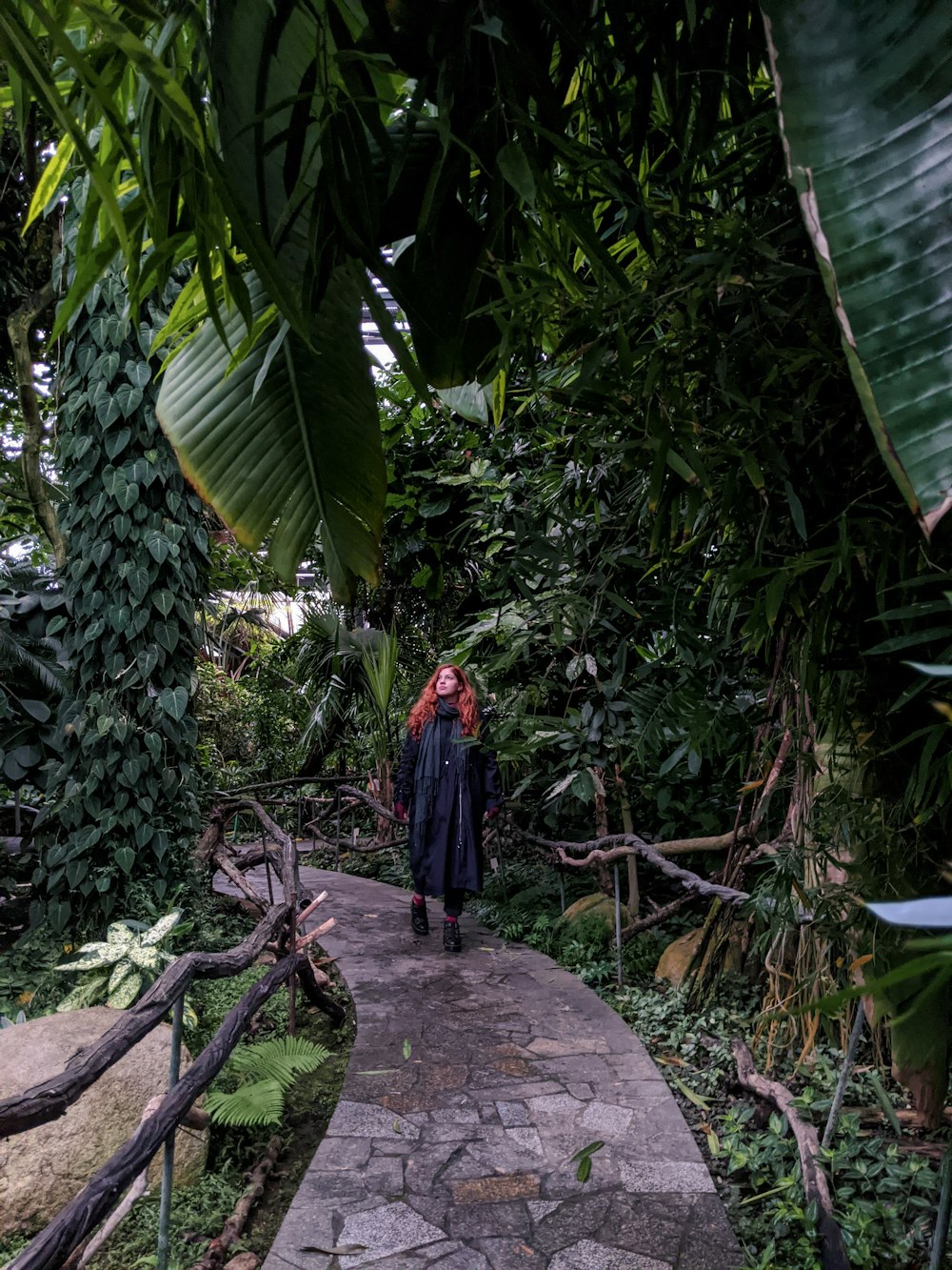 person in blue and red long sleeve shirt walking on gray concrete pathway