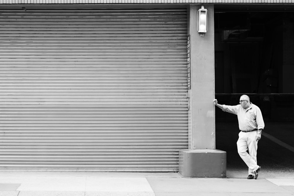 man in white long sleeve shirt and black pants walking on sidewalk during daytime