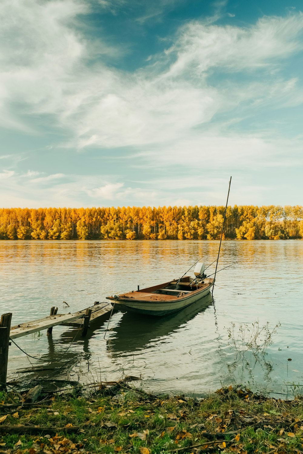 昼間の湖に浮かぶ茶色の木造船