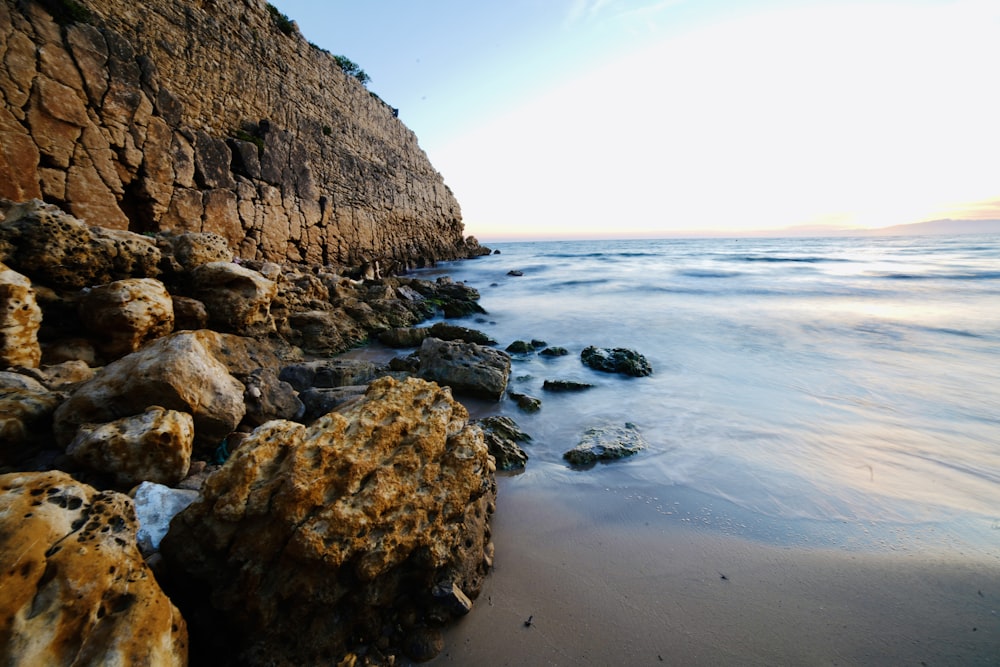 formação rochosa marrom na costa do mar durante o dia