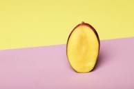 Close-up of a sliced mango revealing its juicy, golden interior on a wooden table.