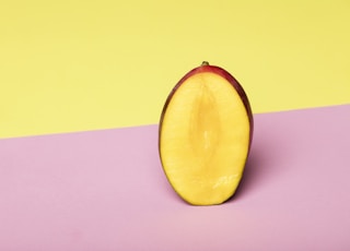 sliced yellow fruit on pink surface