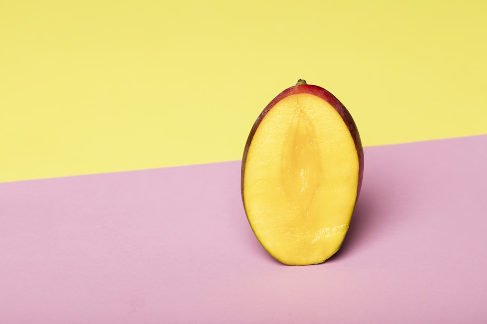 sliced yellow fruit on pink surface