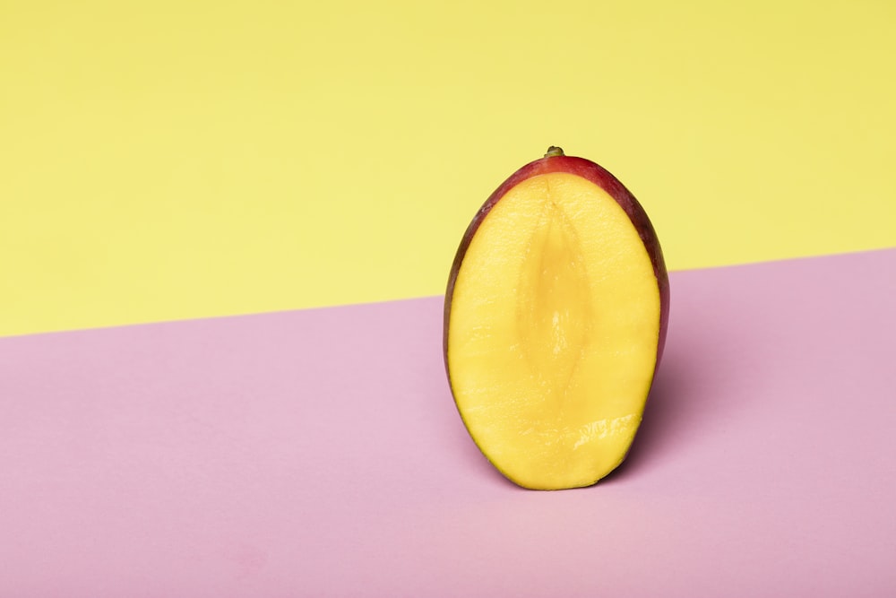 fruits jaunes tranchés sur une surface rose