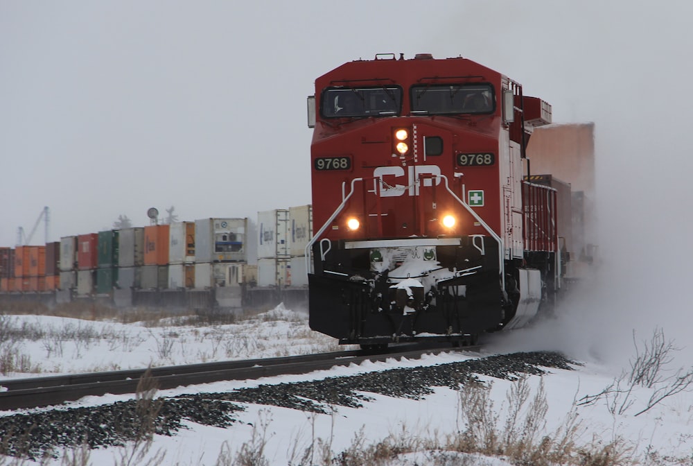 red train on snow covered ground during daytime