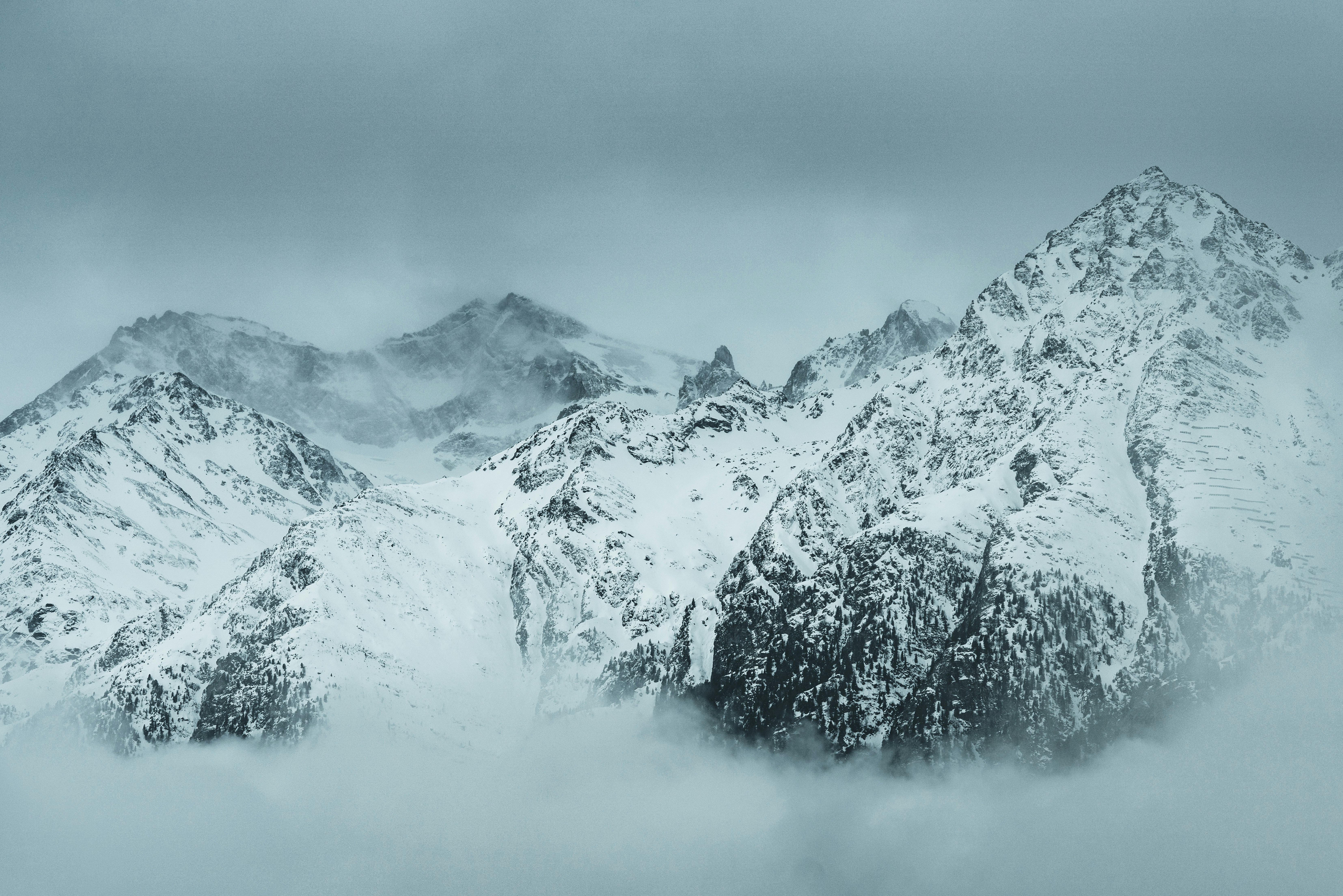 snow covered mountain under cloudy sky