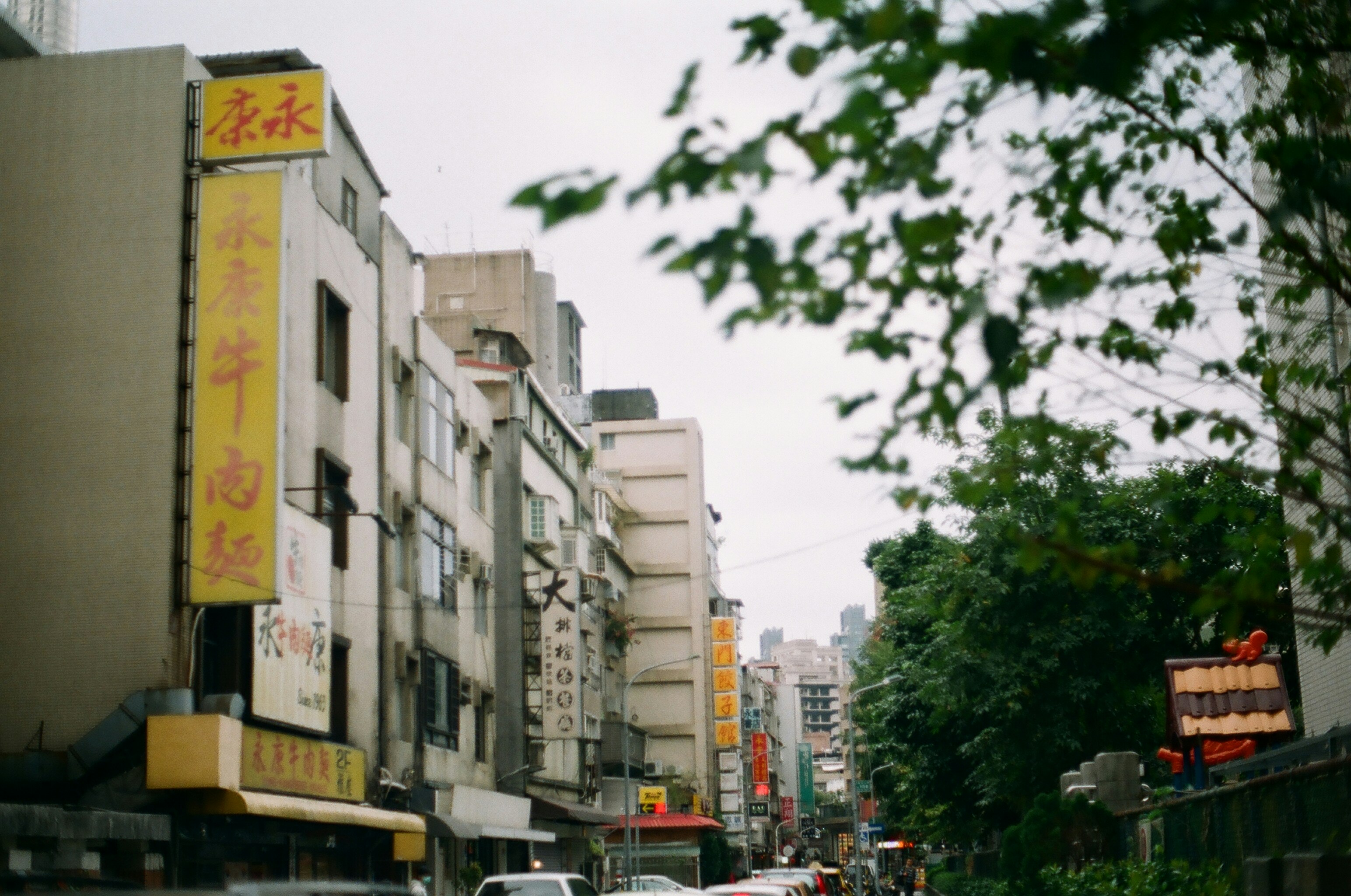 cars parked on side of the road near buildings during daytime