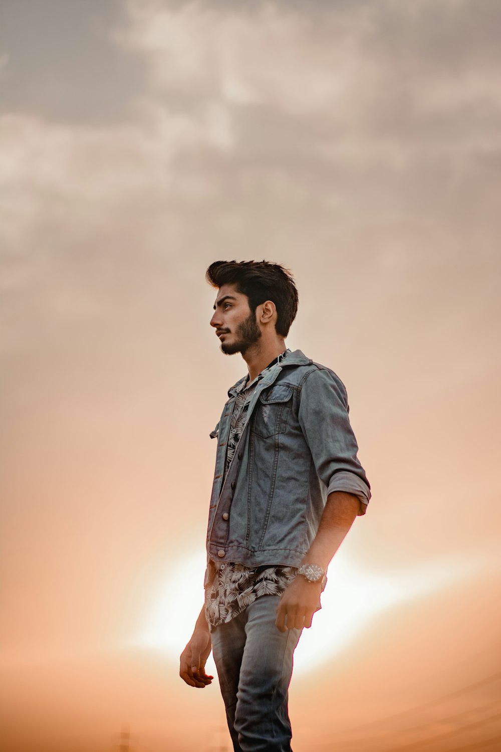 man in blue denim jacket standing under white sky during daytime