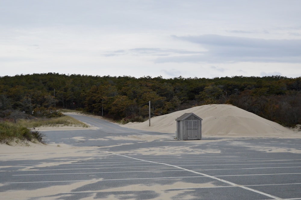 white and gray shed on gray sand during daytime