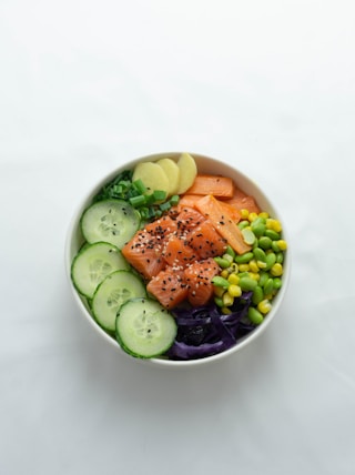 sliced cucumber and cucumber on white ceramic bowl