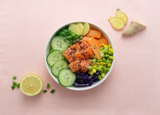 sliced cucumber and sliced lemon on white ceramic bowl