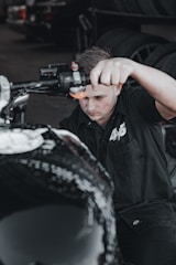 A mechanic working on a motorcycle in a garage.