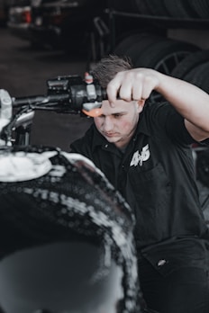 A mechanic working on a motorcycle in a garage.