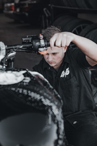 Close-up of a professional changing a motorcycle tire at night with portable equipment.