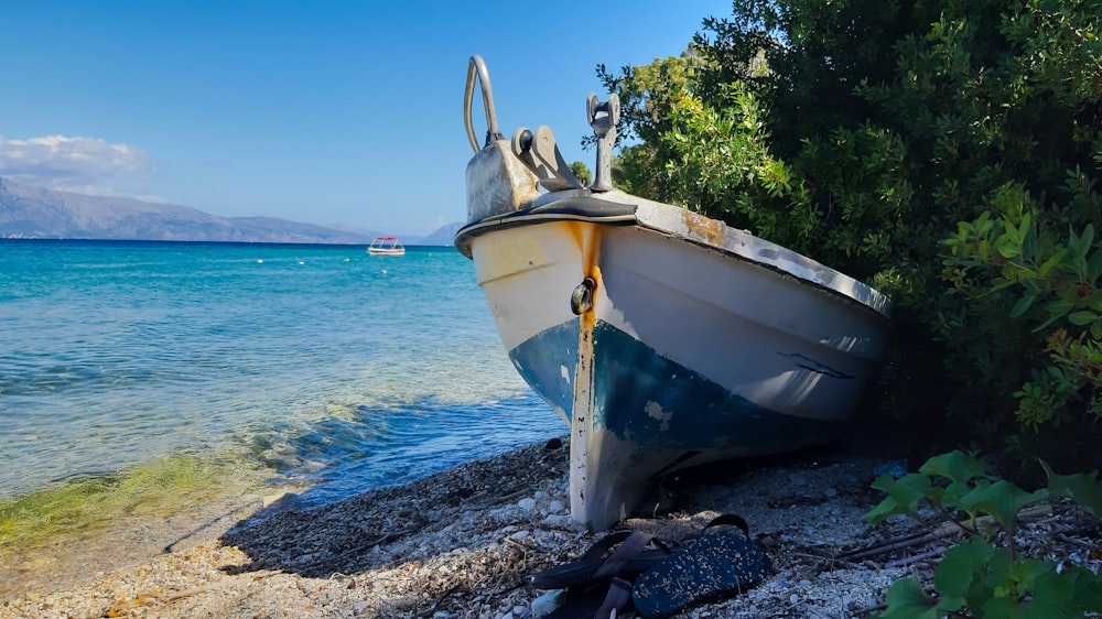 white and yellow boat on shore during daytime