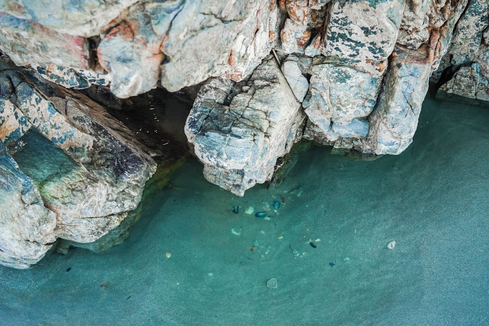 gray rocky mountain beside body of water during daytime