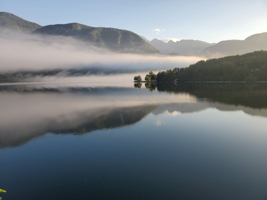 Green mountains beside lake during daytime