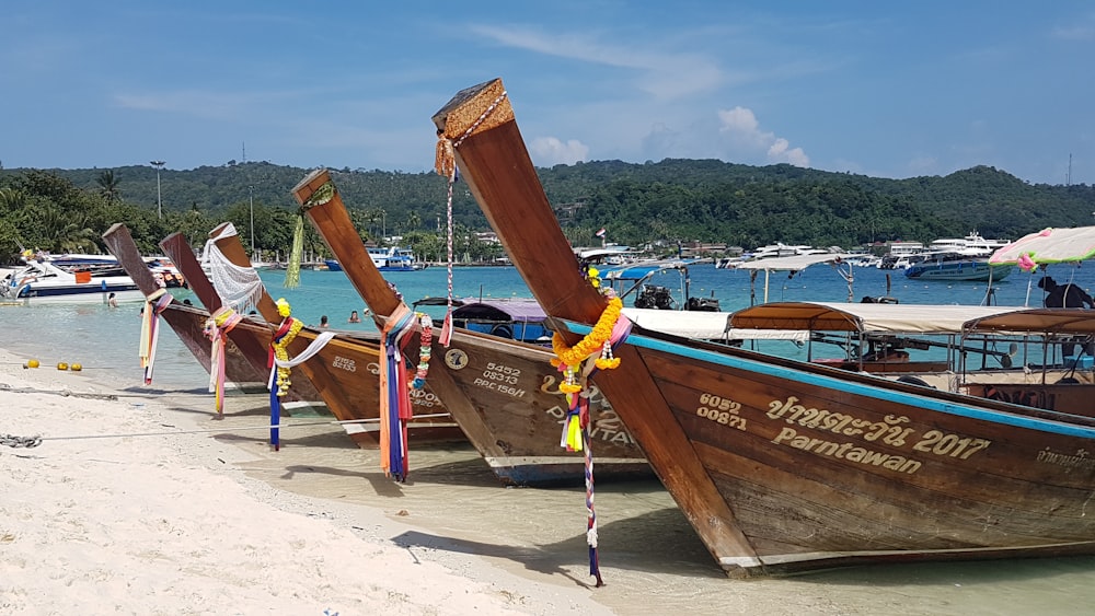 brown wooden boat on white sand during daytime