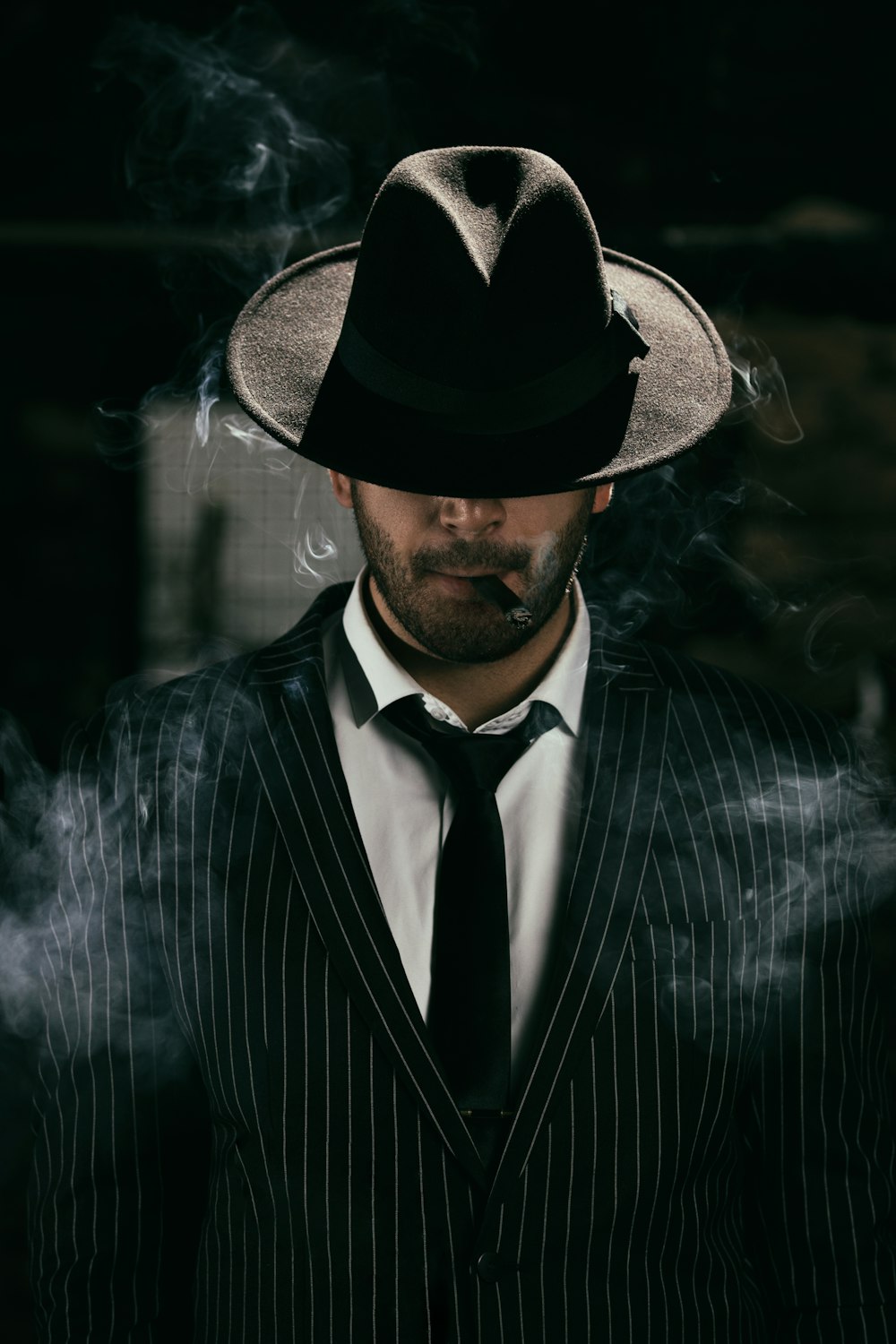 man in black and white pinstripe suit and black fedora hat