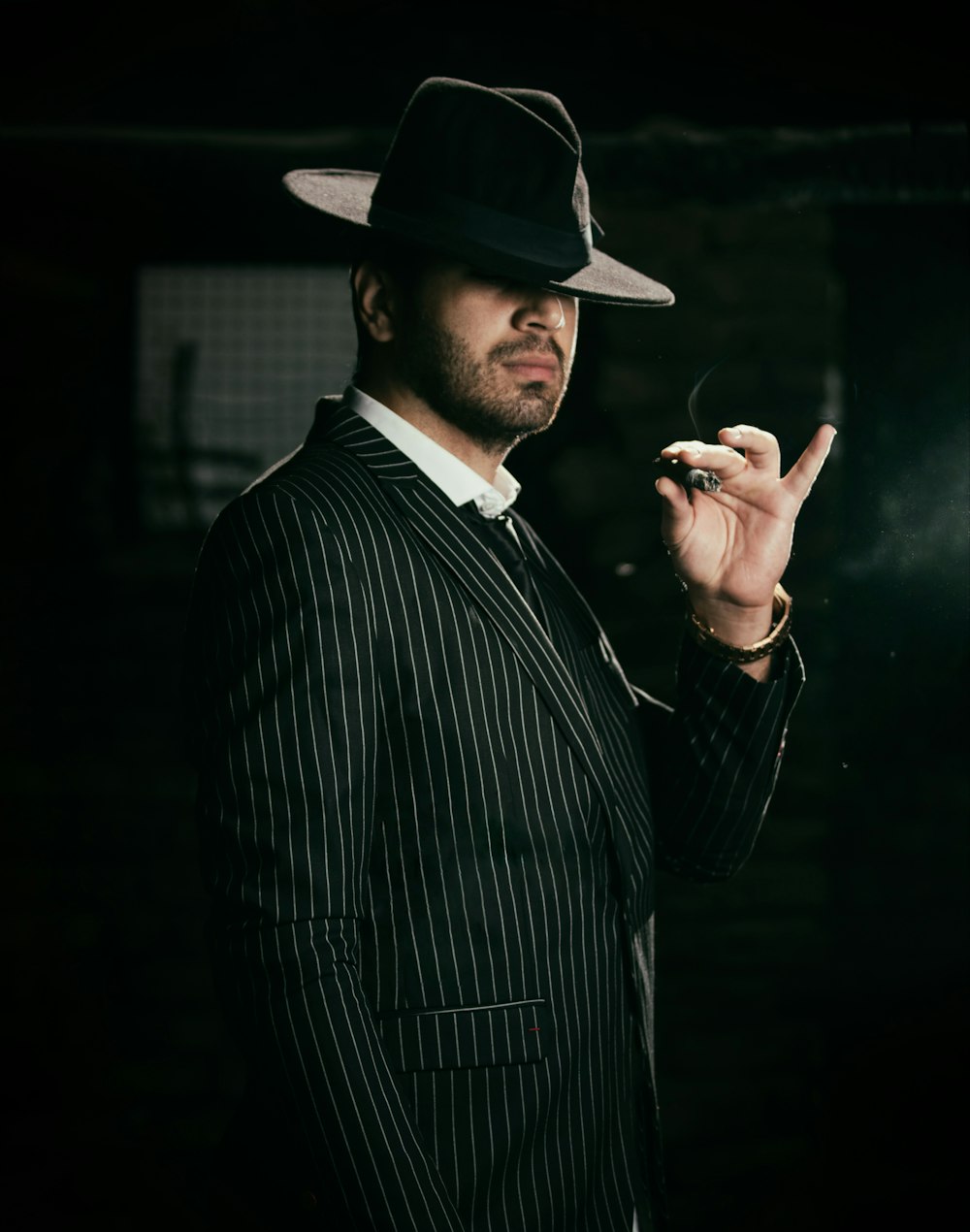 man in black and white pinstripe suit jacket wearing black hat