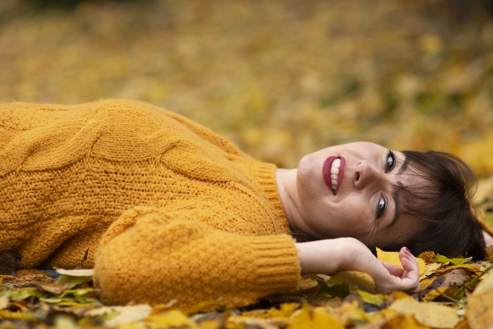 Femme en pull en tricot marron allongée sur le sol