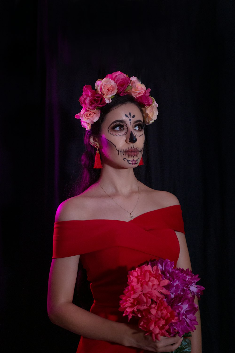 Frau in rotem schulterfreien Kleid mit rosa Blumenkrone