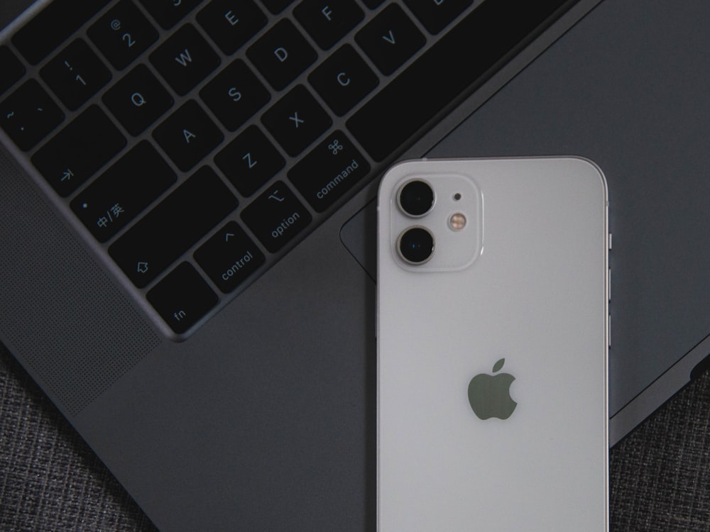 white iphone 5 c on macbook pro