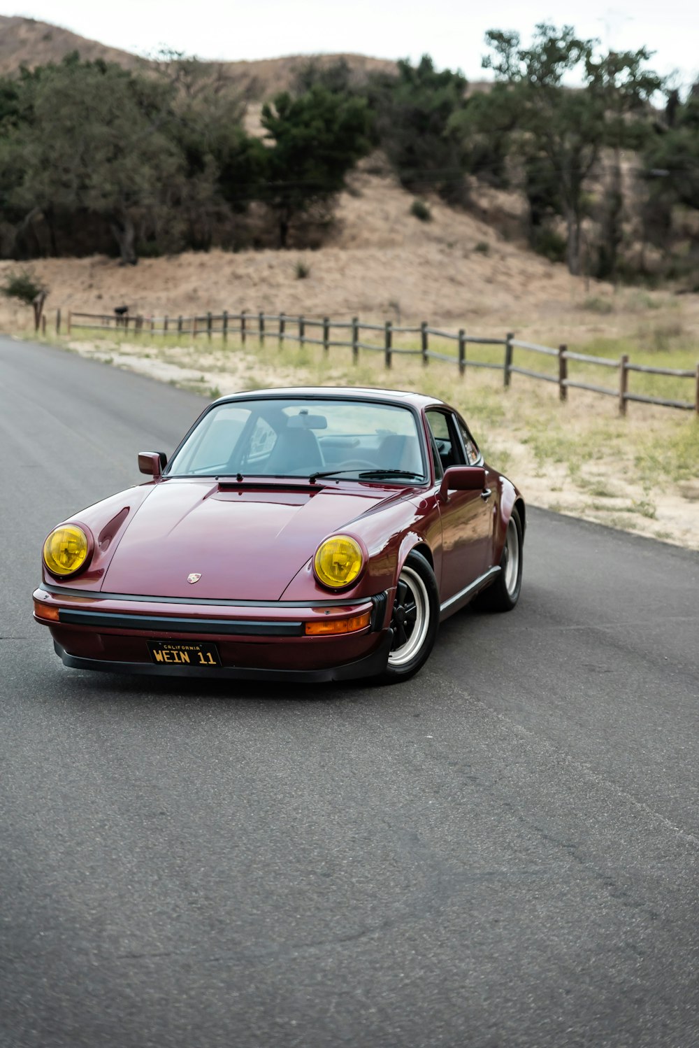 red and yellow porsche 911 on road during daytime