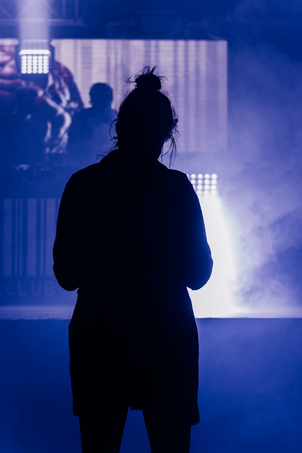 silhouette of woman standing near body of water during daytime