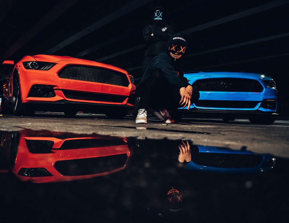 man in black jacket and helmet sitting on red car