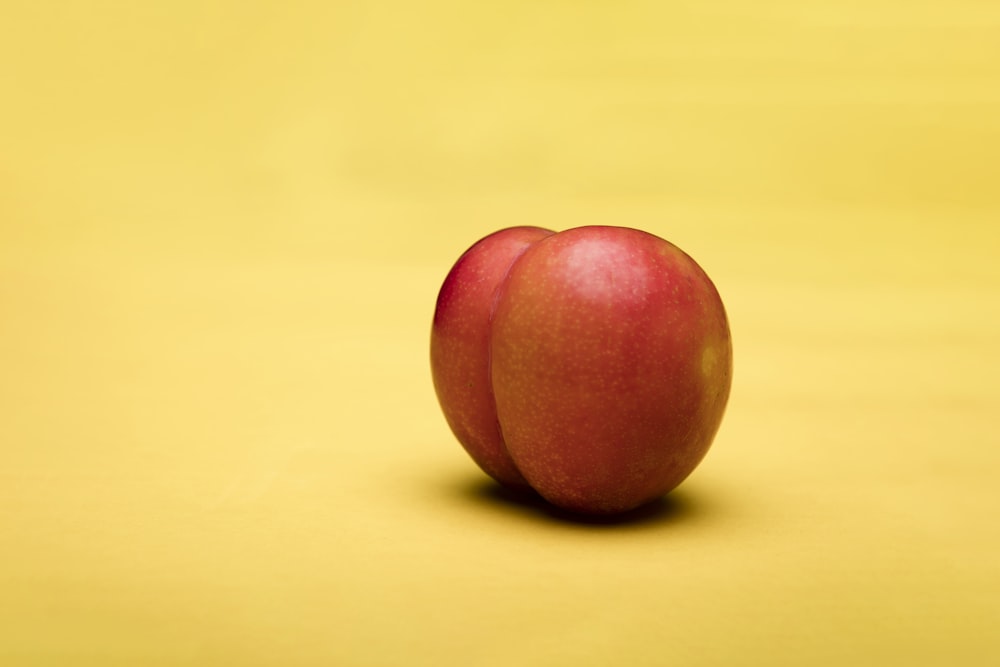 red apple on yellow surface