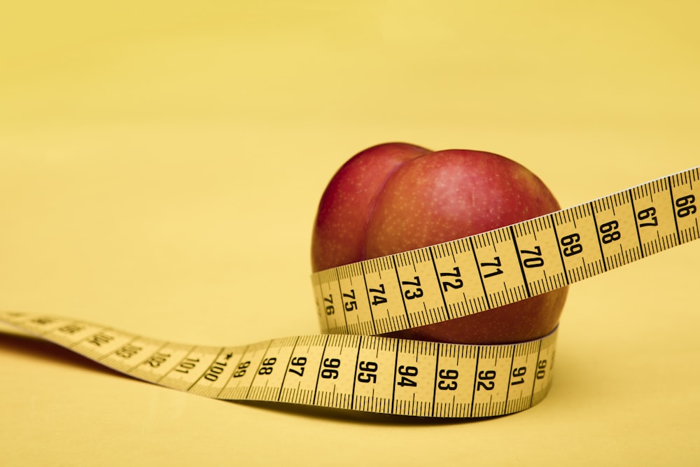 Fruta de manzana roja con cinta métrica