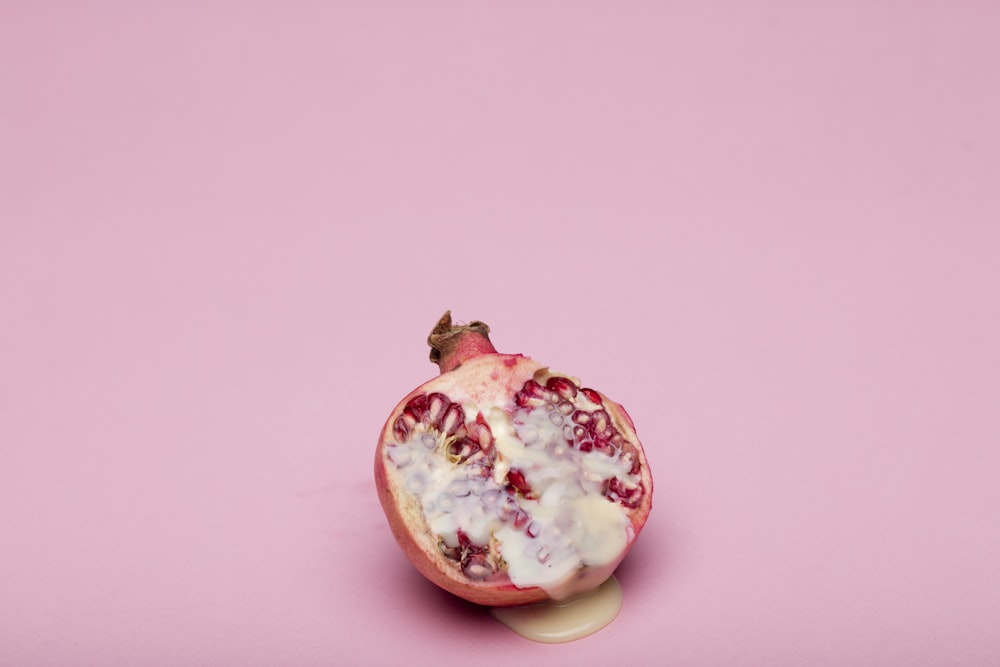 Fruta roja y blanca sobre superficie rosada