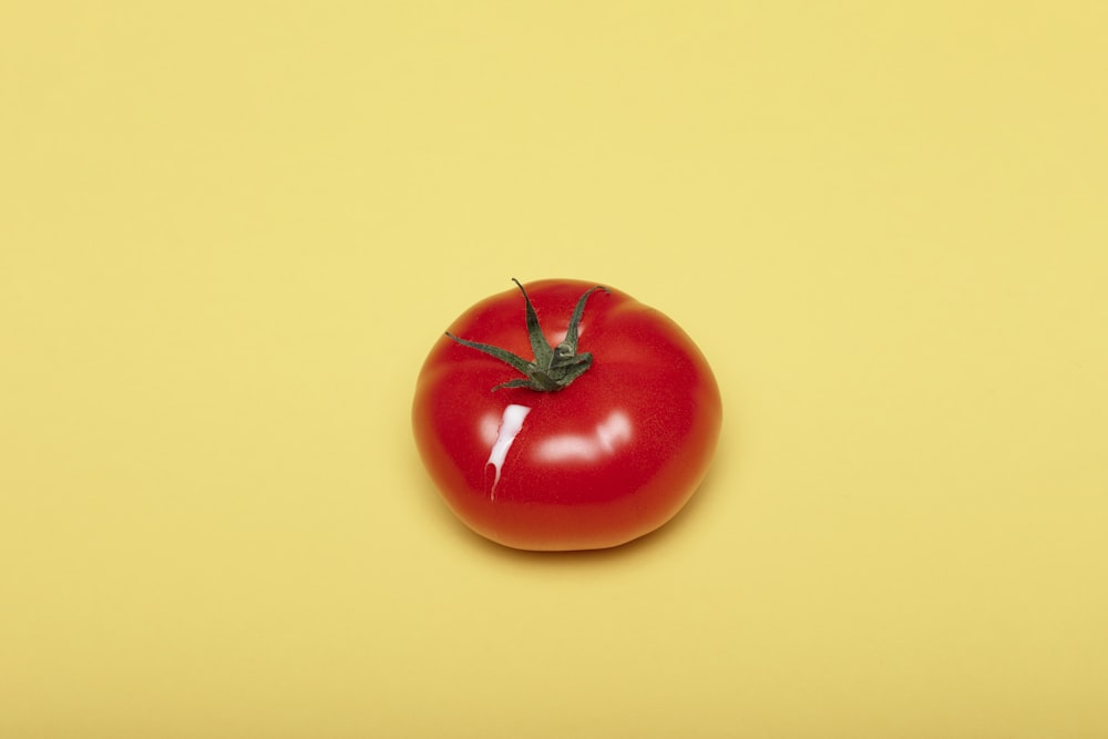 red tomato on yellow surface