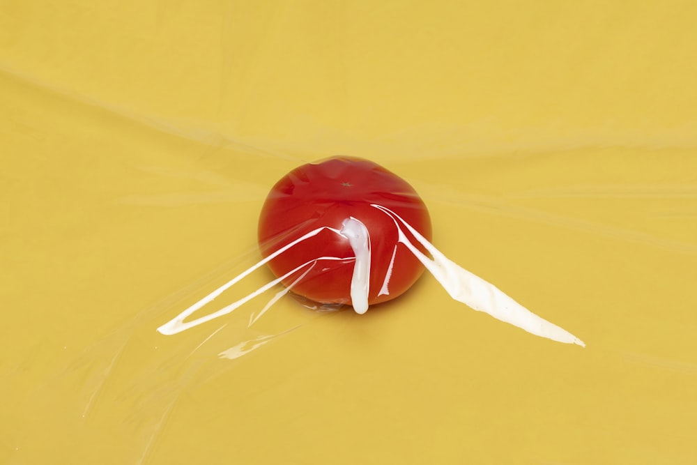 red and white lollipop on yellow surface