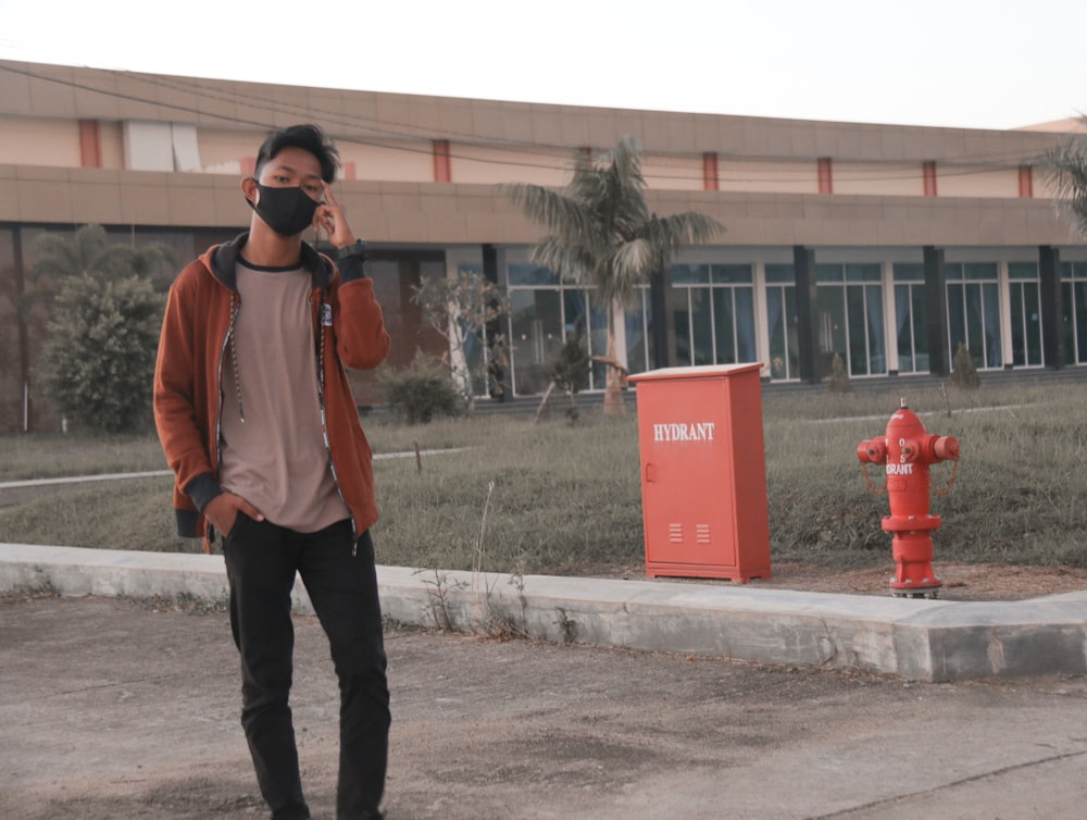 a man standing in front of a red fire hydrant