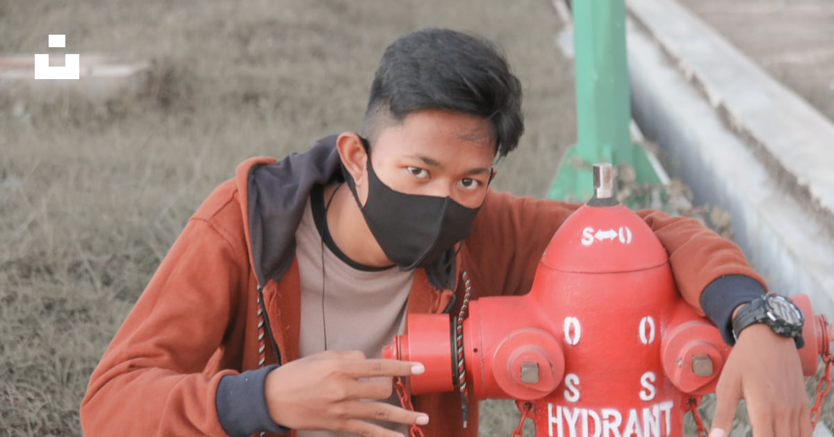 Man In Brown And Black Zip Up Jacket Holding Red Water Jug Photo Free man-in-brown-and-black-zip-up-jacket-holding-red-water-jug-photo-free
