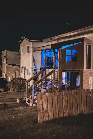 A nighttime view of a residential project illuminated with soft blue exterior lighting.