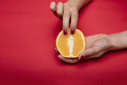 sliced orange fruit on persons hand