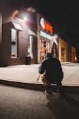Team member setting up bait stations outside a commercial building at dusk.