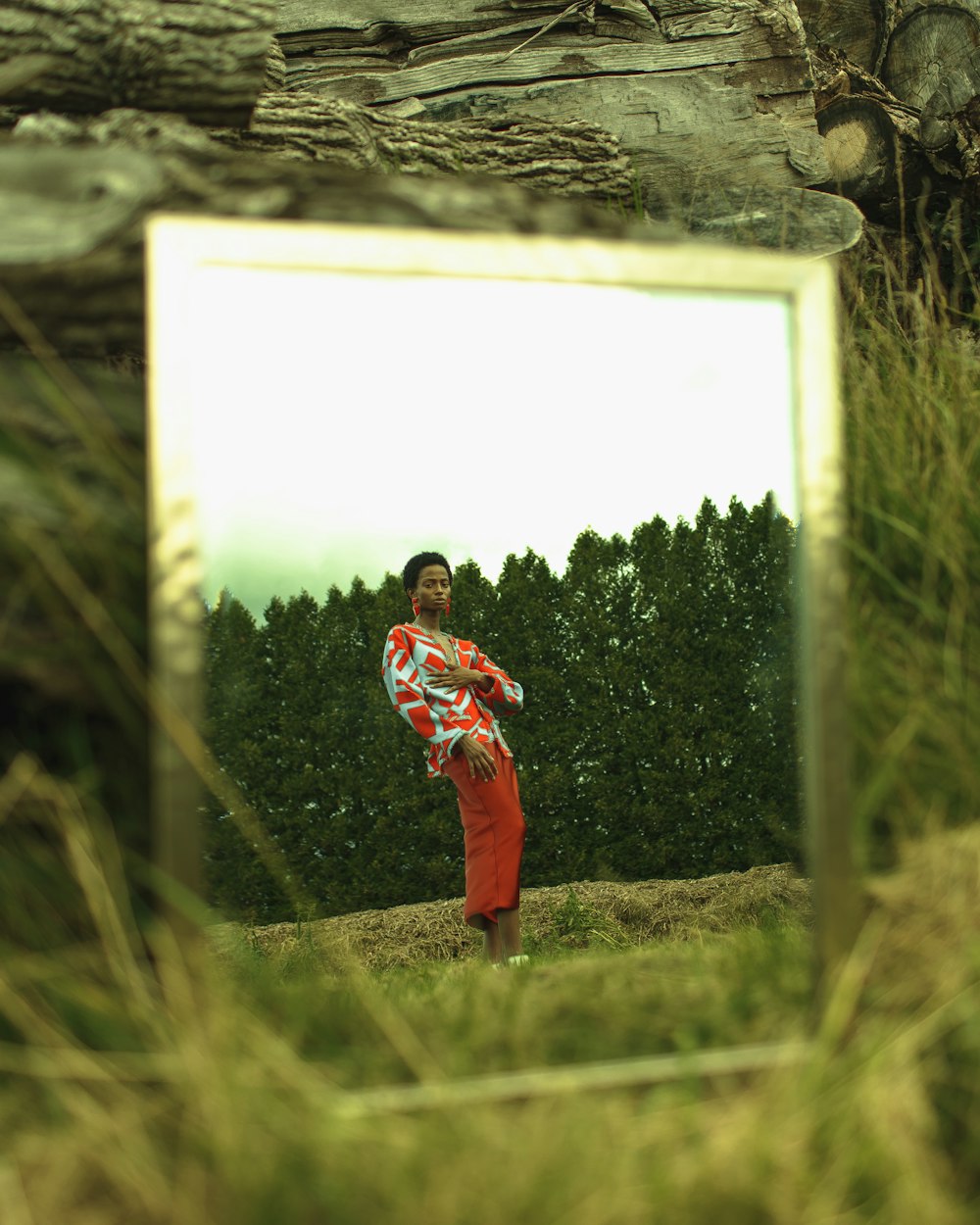 Junge in rot-schwarzem Kapuzenpulli steht tagsüber auf grünem Rasen