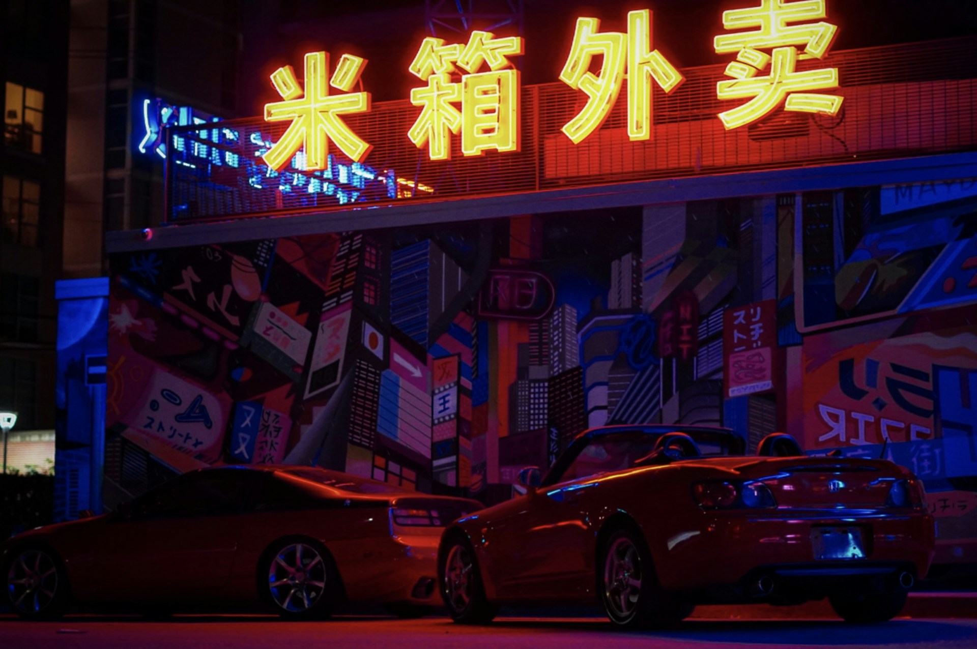 red sedan parked beside red car