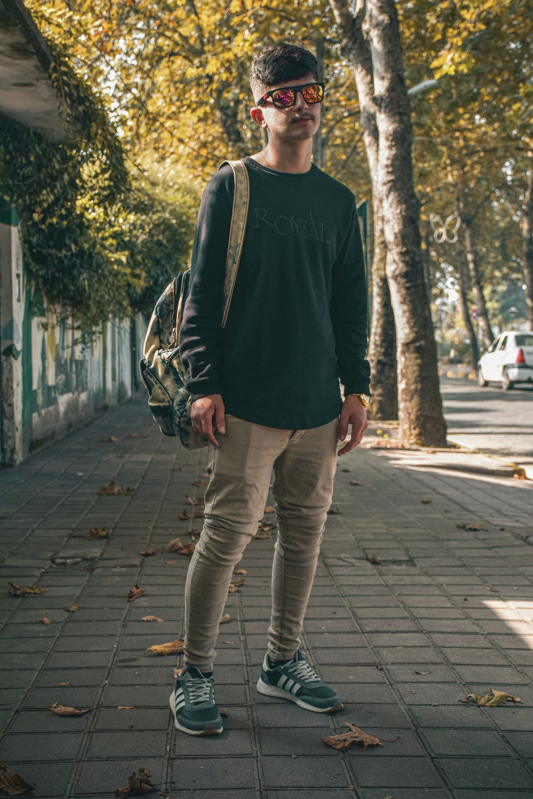 man in black crew neck shirt and gray pants standing on sidewalk during daytime