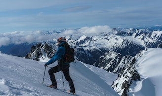 man in blue jacket and black pants riding ski blades on snow covered mountain during daytime