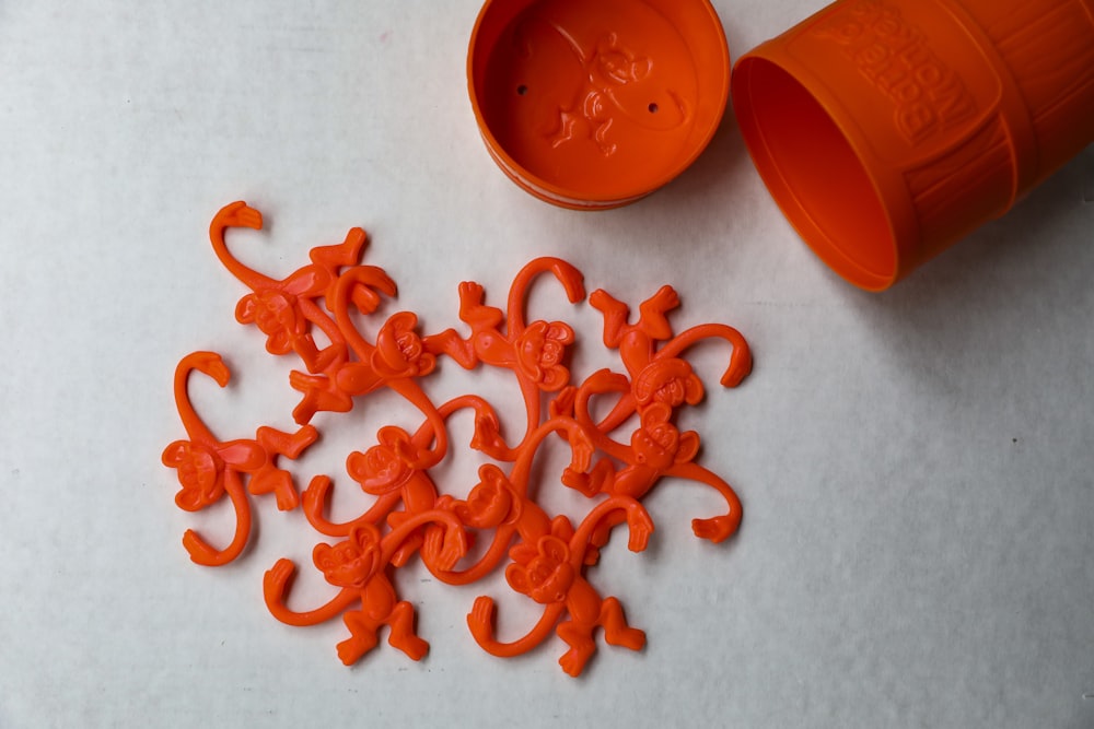 orange plastic beads on white surface